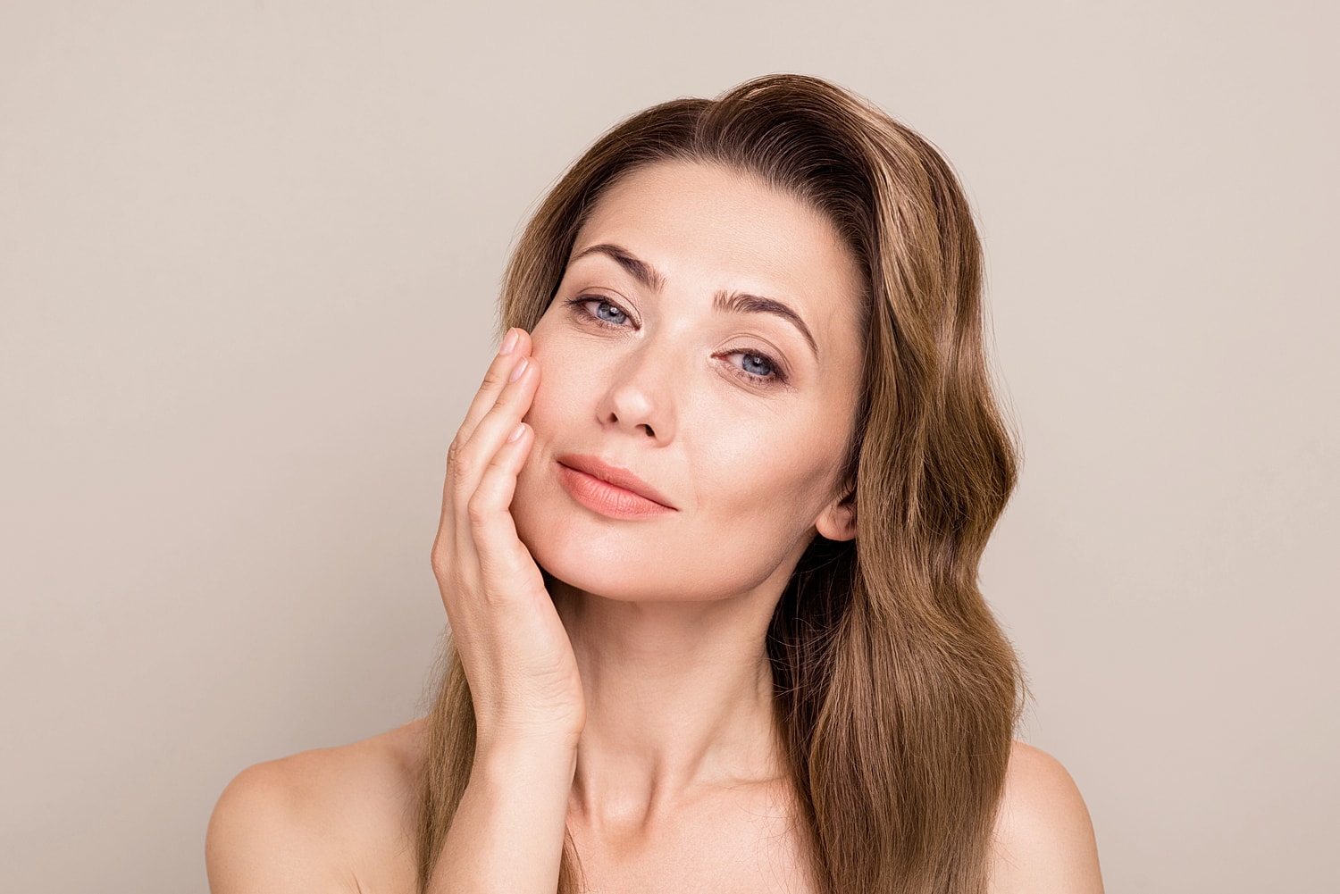 Woman touching face with a gentle smile